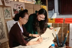 Visitors learn about the process of making Dong Ho folk paintings. (Photo: VNA)