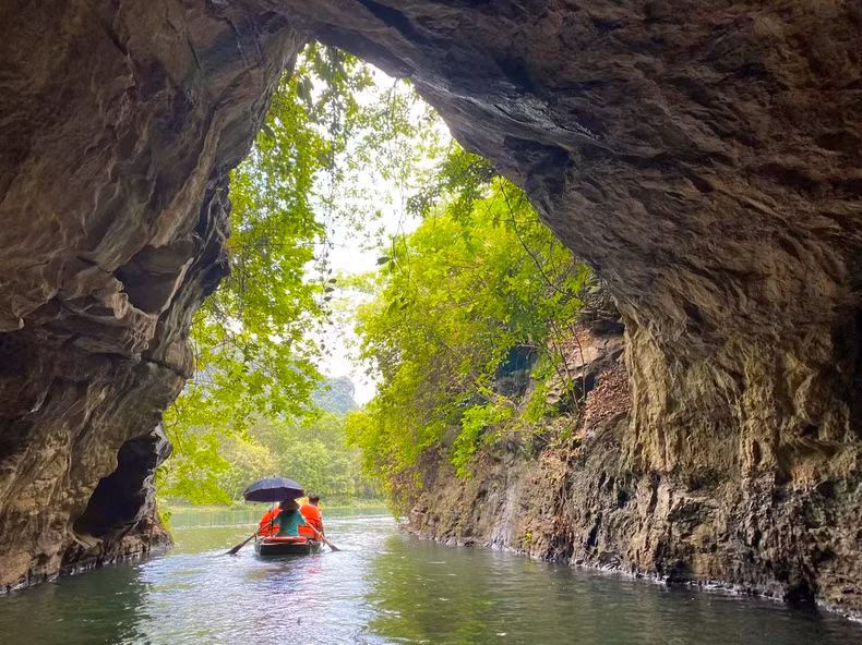 Sitting on a boat to admire the enchanting beauty of Trang An's caves, is an experience favoured by tourists. (Photo: BAO NGOC)
