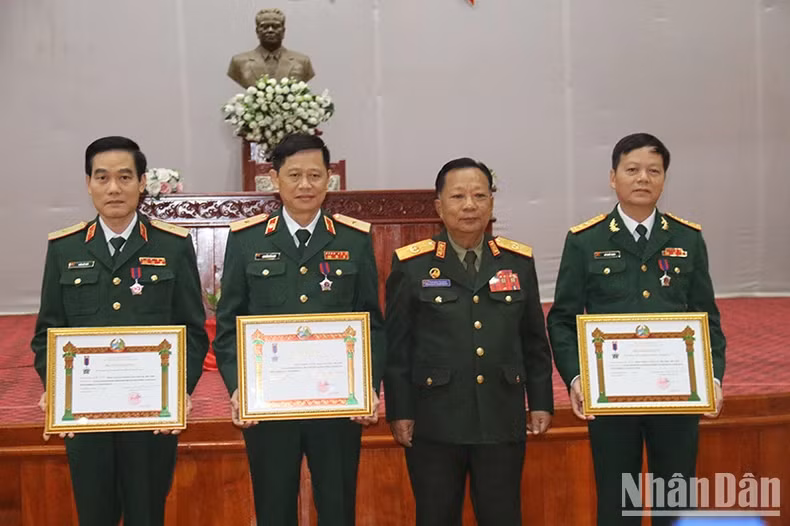 General Chansamone Chanyalath presents the Labour Order to individuals from the Vietnam Military Medical University. (Photo: HAI TIEN)