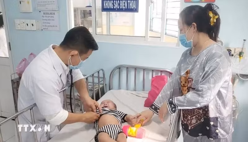 A doctor is treating a baby infected with measles (Photo: VNA)
