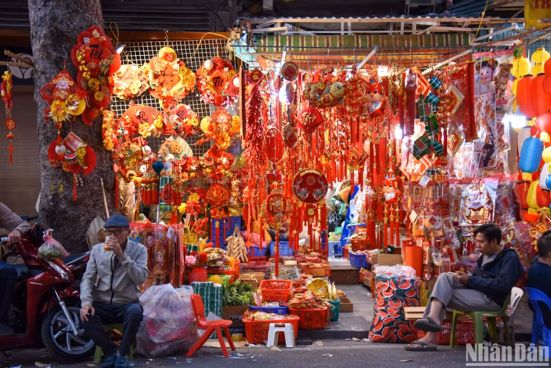 Many items are sold along the street including red couplets, lucky money envelopes, masks, and lanterns.