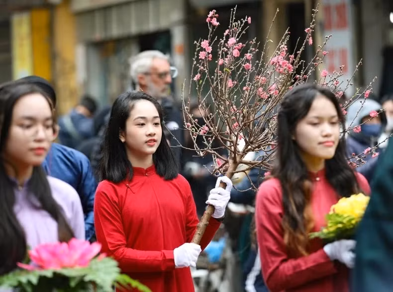 A girl carrying a peach blossom branch in the procession of offerings to the God.
