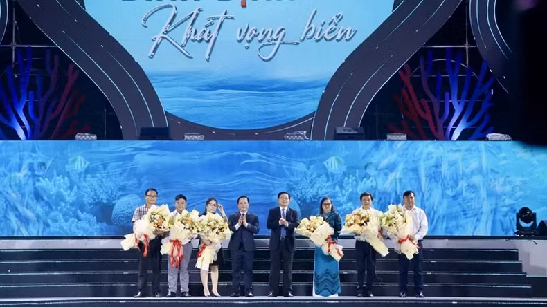 Leaders of the Binh Dinh Provincial People's Committee present flowers to representatives of sponsors.