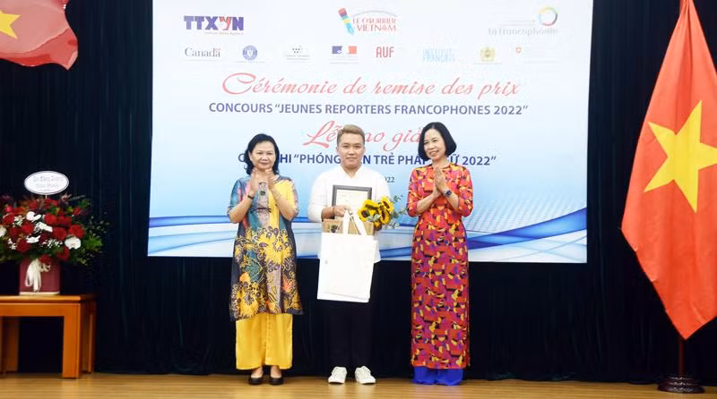 The first-prize winner Ho Ngoc Vinh Nguyen (centre) receive his award from VNA General Director Vu Viet Trang (R) and Tran Thi Mai Yen, acting Chief Representative of the OIF in the Asia-Pacific region. (Photo: VNA) 