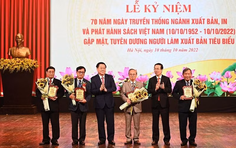 Politburo member Vo Van Thuong and Party official Nguyen Trong Nghia presents honourary badges to five senior officials in the book publishing sector. (Photo: the organising board)
