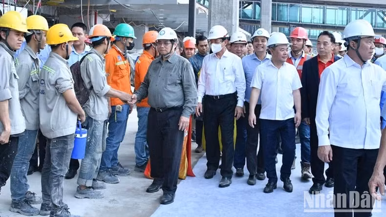 Prime Minister Pham Minh Chinh (second from the right) extends New Year greetings to workers at the construction site of the Terminal 3 project at Tan Son Nhat International Airport in Ho Chi Minh City. (Photo: NDO)