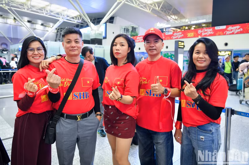 At the airport, fans are ready to board their flight to Bangkok (Thailand).