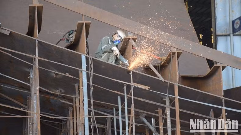 At Nam Trieu Shipyard, workers are assembling and connecting ship sections during the vessel construction process.