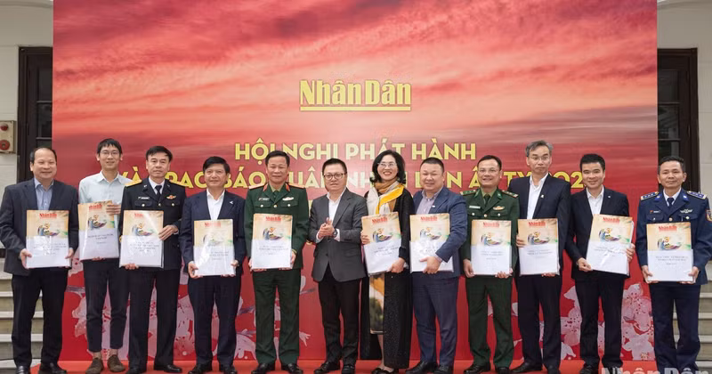 Editor in Chief of Nhan Dan Newspaper Le Quoc Minh, along with other delegates, presents Tet newspapers to representatives of the recipients. 