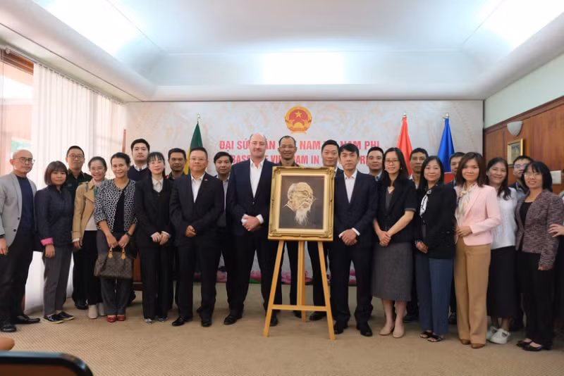 Vietnamese Ambassador to South Africa Hoang Sy Cuong and other delegates pose for a commemorative photo with the family of South African artist Jan van Rooyen beside his oil portrait of President Ho Chi Minh. (Photo: VNA) 