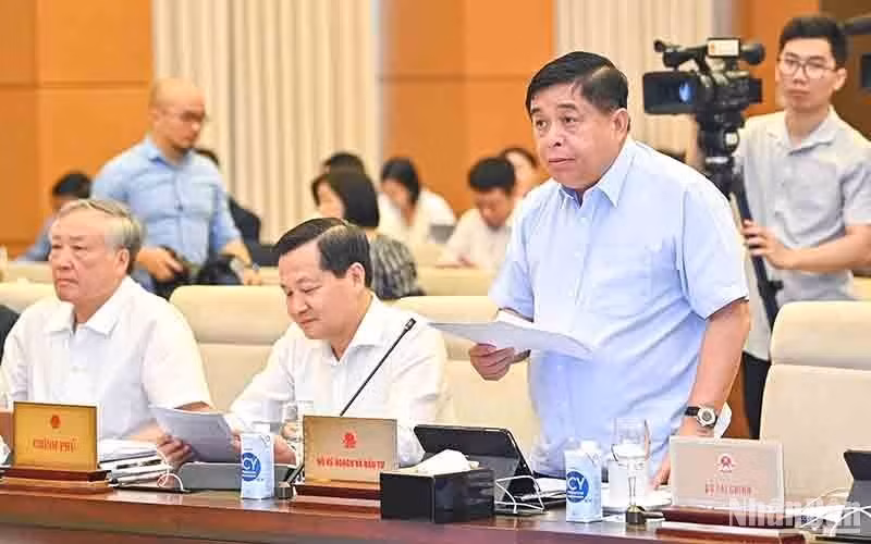 Minister of Planning and Investment Nguyen Chi Dung presents a report on socio-economic situation at the session.