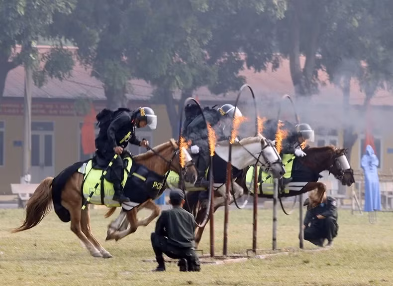 The Cavalry Mobile Police soldiers jump through rings of fire. (Photo: VNA) The Cavalry Mobile Police soldiers jump through rings of fire. (Photo: VNA)
