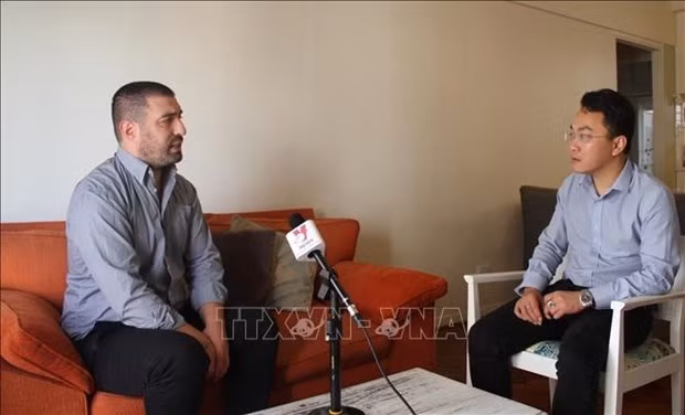 Journalist Gaston Fiorda talks with Vietnam News Agency reporter. (Photo: VNA)