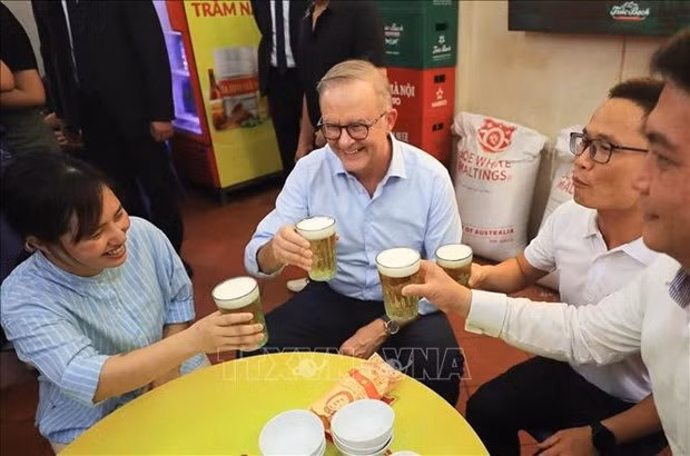 Australian Prime Minister Anthony Albanese enjoys locally brewed beer (bia hoi) with young people. (Photo: VNA)