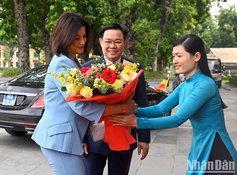 A receptionist of the NA Office presents flowers to President of the Belgian Senate Stephanie D'Hose.
