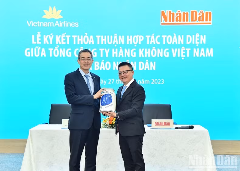 Nhan Dan Newspaper’s Editor-in-chief Le Quoc Minh presents the souvenir to Chairman of the Board of Management of Vietnam Airlines Dang Ngoc Hoa.
