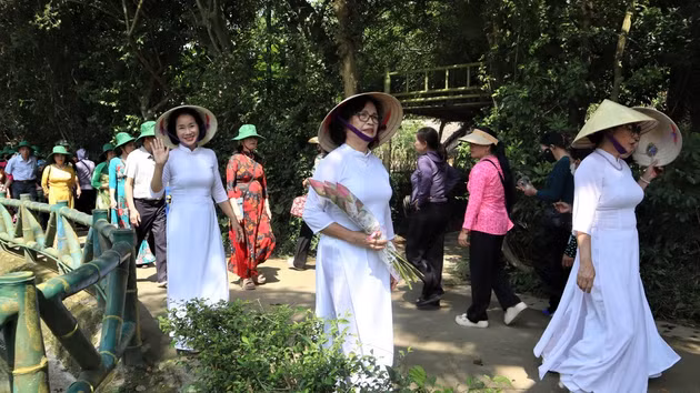 People respectfully offer lotus flowers and lilies to Him.