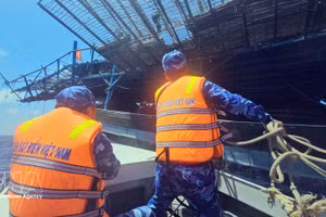 Officers and soldiers aboard Ship 314 approach the distressed fishing vessel QNa 91117 TS (Photo: VNA)