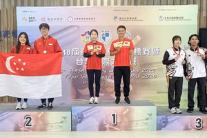 Gold medallists Le Thi Mong Tuyen and Nguyen Thanh Nam celebrate on the podium. (Photo: qdnd.vn)