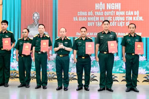 Colonel Nguyen Dinh Chuan, Deputy Political Commissar of the municipal Military Command and Deputy Head of the Ho CHi Minh City’s Steering Committee 515, hands over decisions to assign personnel to the specialised force tasked with searching for and recovering the remains of fallen soldiers. (Photo: NDO)