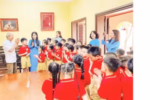 Cong Ngoc Dung tells stories about President Ho Chi Minh to teachers and students of Phu Thuong Primary School during a local history lesson at the relic site of Nguyen Thi An's house.
