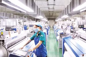 A worker inspects the operation of automated weaving machines at Textile Factory – Corporation 28, under the General Department of Logistics and Technology.