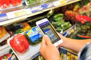 A consumer scan QR codes to verify product information and origins at a supermarket in Ha Noi. (Photo: Ha Thu)
