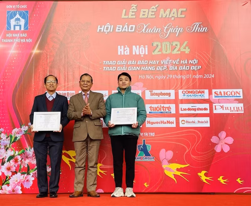 A Nhan Dan representative receives the first prize for beautiful display booth.
