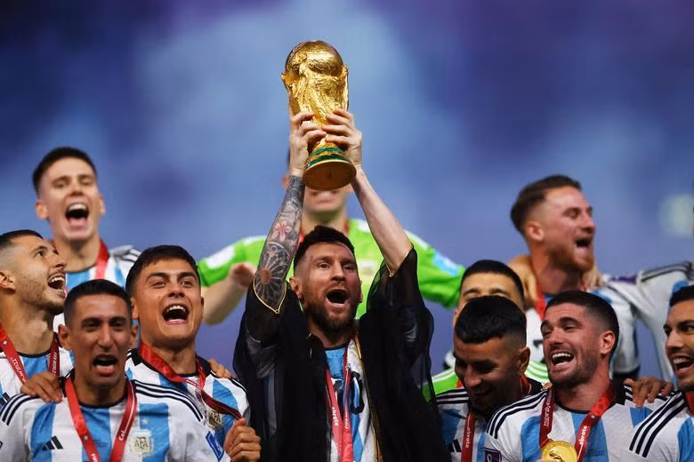 Argentina's Lionel Messi lifts the World Cup trophy alongside teammates as they celebrate after winning the World Cup. REUTERS/Kai Pfaffenbach