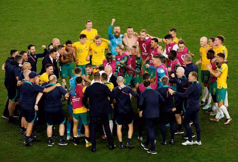 Australia coach Graham Arnold celebrates with his players and staff after qualifying for the knockout stages. REUTERS/Albert Gea