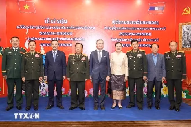 Participating Vietnamese and Lao delegates pose for a group photo at the ceremony. (Source: VNA)