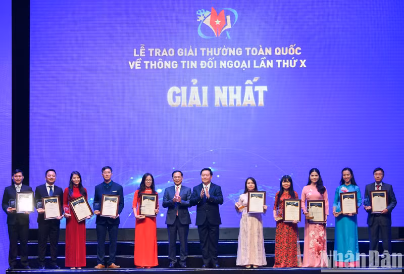 Politburo member, Secretary of the Party Central Committee and Chairman of its Commission for Information and Education Nguyen Trong Nghia and Deputy Prime Minister and Minister of Foreign Affairs Bui Thanh Son present awards to authors and groups of authors that win the first prize. (Photo: Thanh Dat)