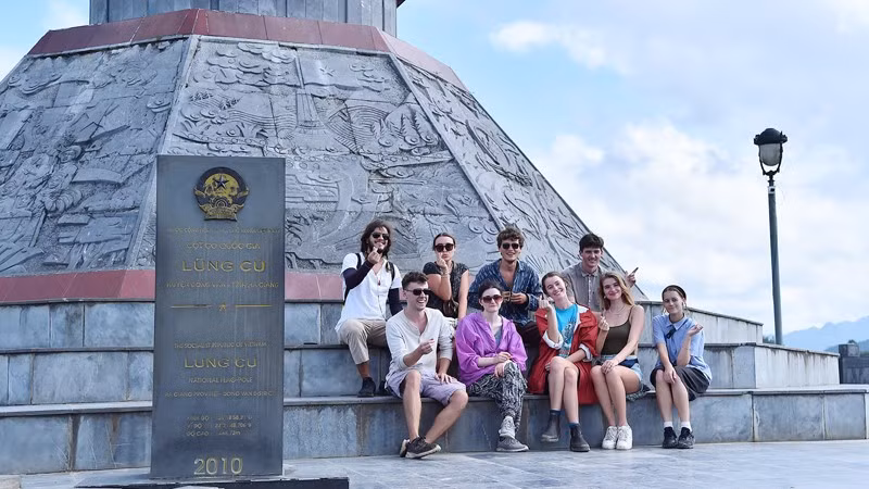 Foreign visitors pose for a photo at Lung Cu Flag Tower in Ha Giang Province. (Photo: Thuy Nguyen)