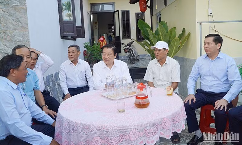 Head of the Central Commission for Internal Affairs Phan Dinh Trac is briefed on new rural construction in Duy Vinh Commune.