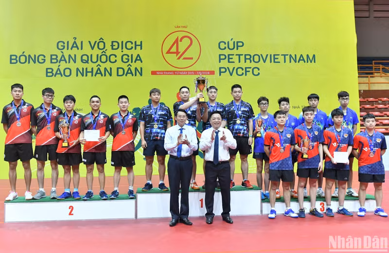 Nhan Dan's Deputy Editor-in-chief Que Dinh Nguyen presents the cup and medals to the winning teams.