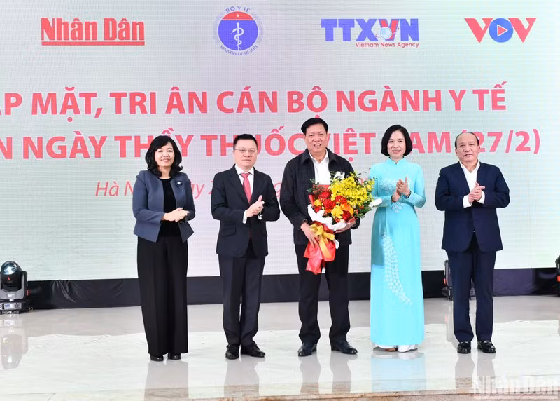 Leaders of press agencies present flowers to Deputy Health Minister Do Xuan Tuyen. (Photo: Dang Khoa)