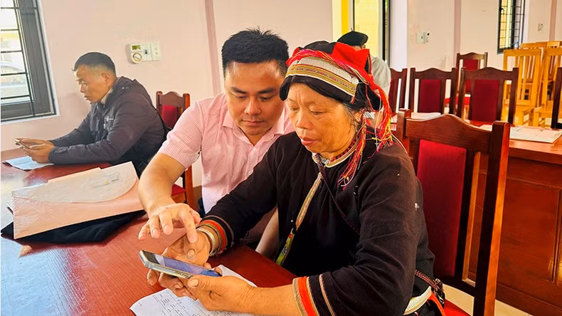 A VBSP official instructs people on how to use a mobile app to manage their policy credit.