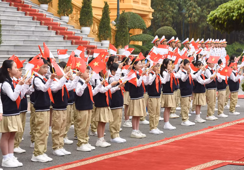 Children wave at the two prime ministers and their spouses.