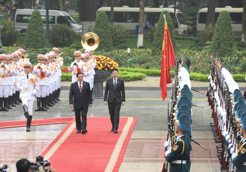 Prime Minister Pham Minh Chinh and his Singaporean counterpart Lawrence Wong review the honour guard of the Vietnam People’s Army. (Photo: NDO/Tran Hai)