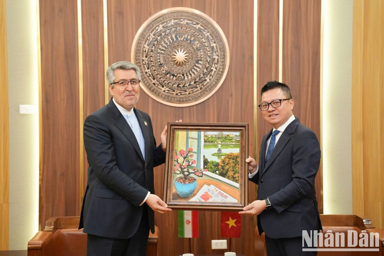 Nhan Dan’s Editor-in-chief Le Quoc Minh presents a painting to Iranian Ambassador Ali Akbar Nazari. (Photo: Khac Anh)