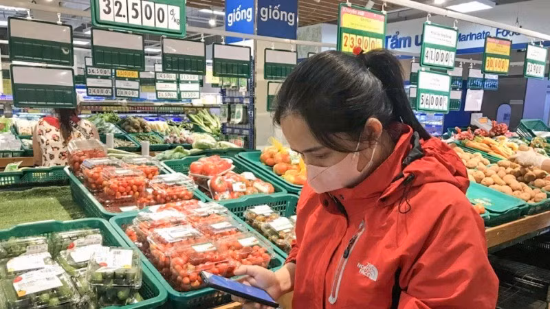 A consumer checks the origin of products at a supermarket in Buon Ma Thuot, Dak Lak Province. (Photo: Do Lan)