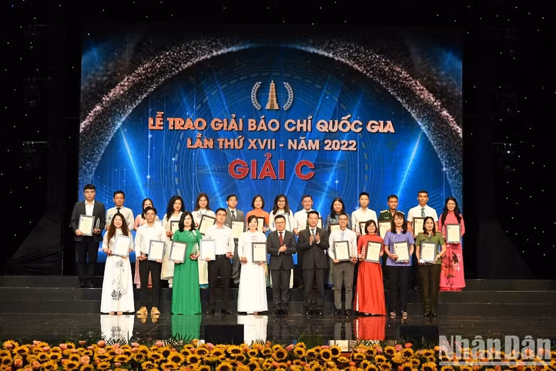 Nhan Dan’s Editor-in-chief Le Quoc Minh and Minister of Information and Communications Nguyen Manh Hung present the C prizes for winning journalists.