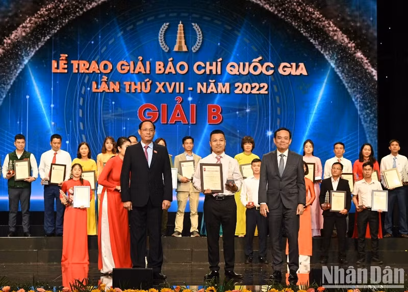 Deputy PM Tran Luu Quang and National Assembly Vice Chairman Tran Quang Phuong present a B prize to a journalist from Nhan Dan.