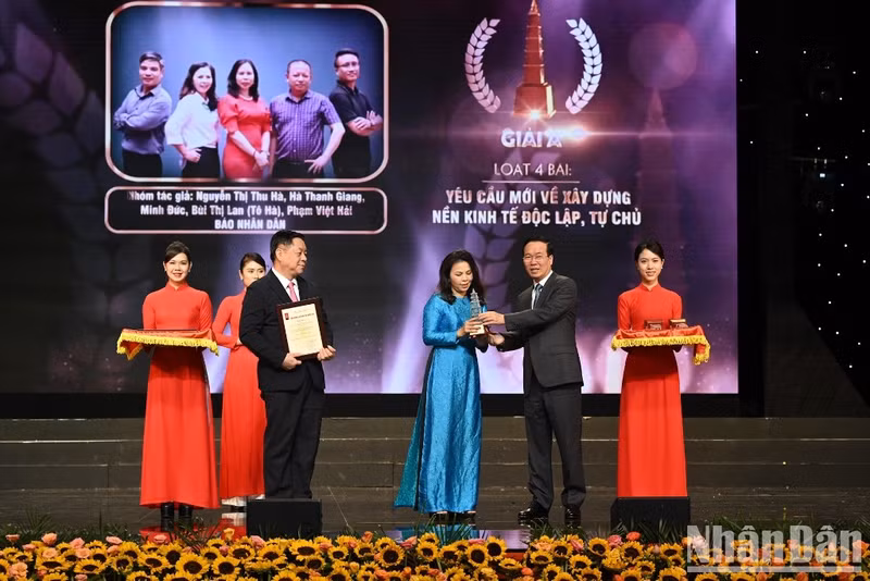 President Vo Van Thuong presents the A prize to a journalist of Nhan Dan Newspaper.