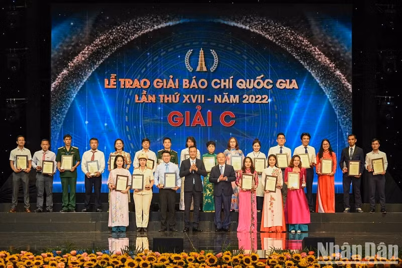 VTV General Director Le Ngoc Quang and VOV General Director Do Tien Sy present the C prizes to winning journalists.