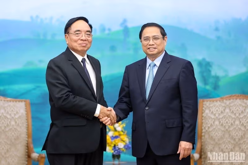 Prime Minister Pham Minh Chinh shakes hands with Lao Minister of Planning and Investment Khamchen Vongphosy. (Photo: Tran Hai) 