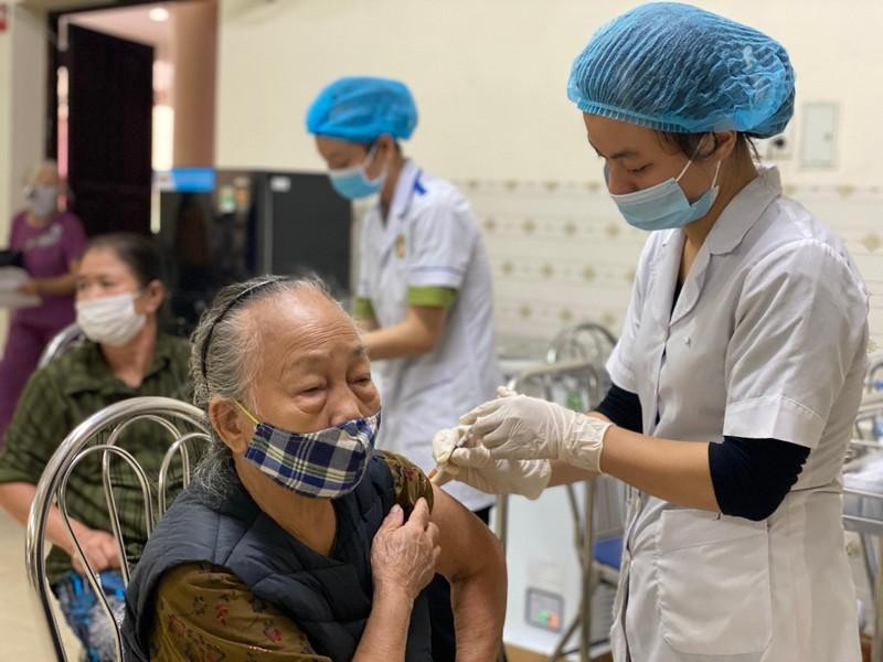 An old woman is vaccinated against COVID-19.
