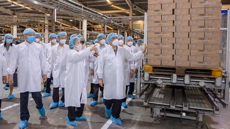 Vinamilk CEO Mai Kieu Lien takes the Prime Minister for a tour of the company's milk plant in Binh Duong Province.