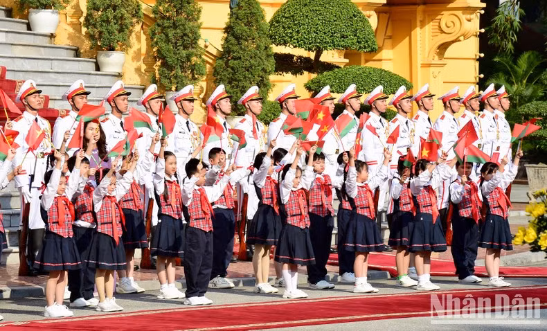 Children wave flags to the two Prime Ministers.