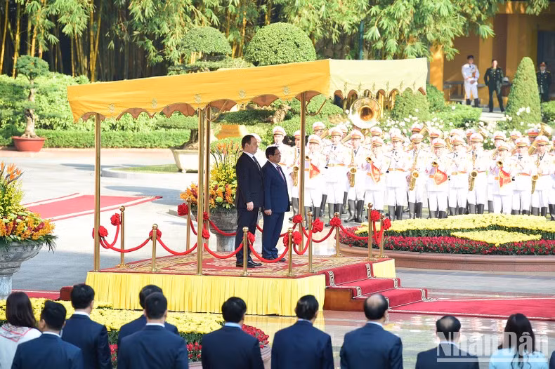 Prime Minister Pham Minh Chinh and Belarusian Prime Minister Roman Golovchenko perform the flag salute ceremony.